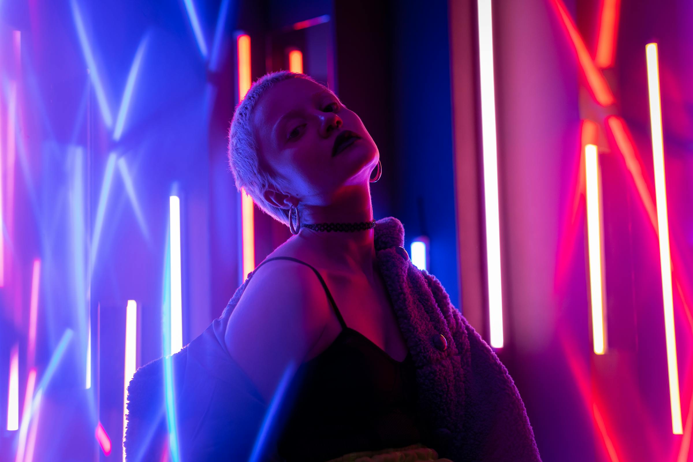 Young woman illuminated by vibrant neon lights, representing the warmth and presence of an AI companion
