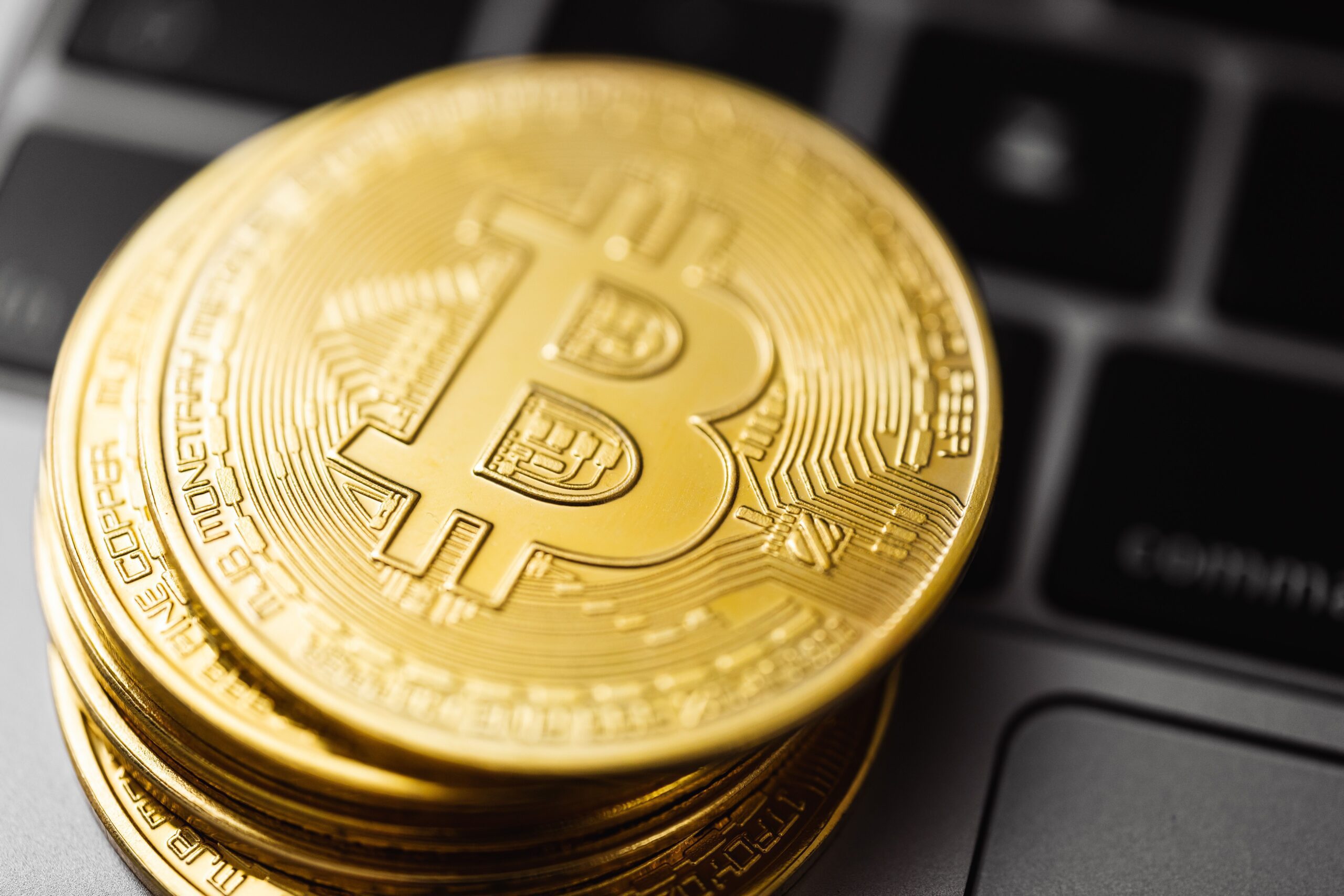 Bitcoin coins arranged on a dark surface, evoking the inscription on a coinbase block.