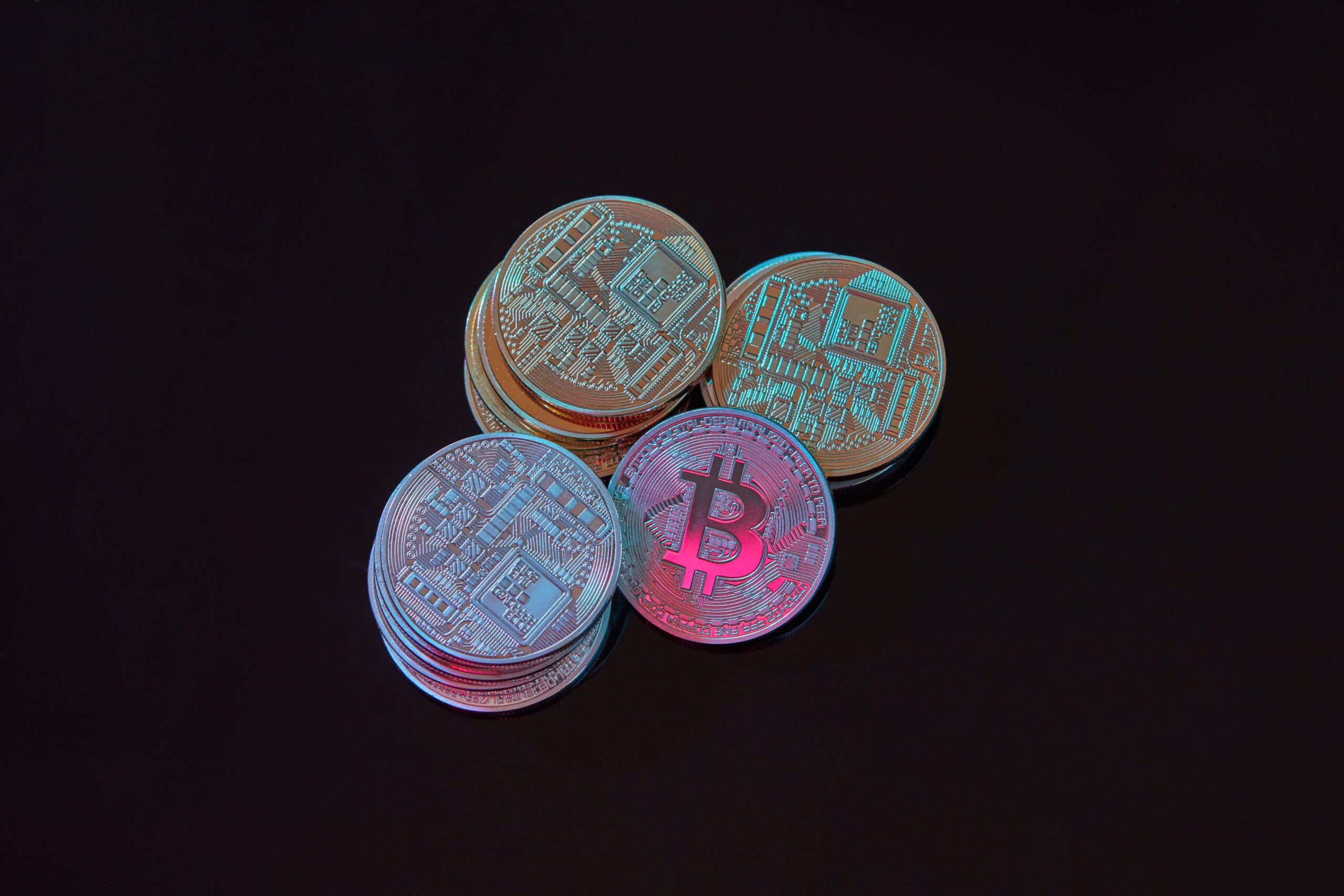 A single gold bitcoin lit by one light source against a dark monumental background